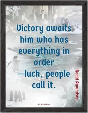 A black framed print with a quote from Roald Amundsen, 'Victory awaits him who has everything in order—luck people call it'.